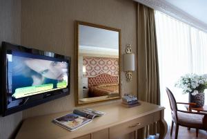 Habitación de hotel con TV y espejo. en Emre Beach & Emre Hotel en Marmaris
