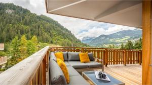 balcón con sofá y vistas a las montañas en Les Freinets - Apt A01 - BO Immobilier en Châtel