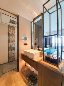 Un baño con lavabo y un espejo grande. en Howard Johnson Plaza by Wyndham Blue Bay Sihanoukville, en Sihanoukville