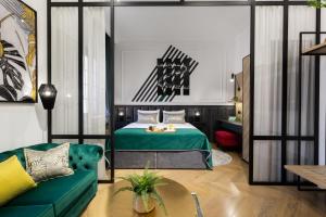 a bedroom with a green bed and a couch at DeZign Superior Apartments & Rooms in Zadar