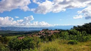 un petit village sur une colline avec un lac en arrière-plan dans l'établissement House Pod Humom, à Jelsa