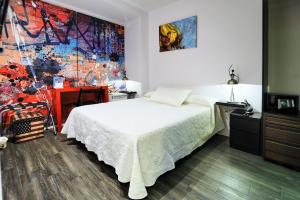 a bedroom with a bed and a painting on the wall at Hotel Boutique Sabbia Valencia in Valencia