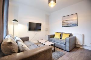 a living room with two couches and a tv at Talbot Steel - Place to Stay! in Port Talbot
