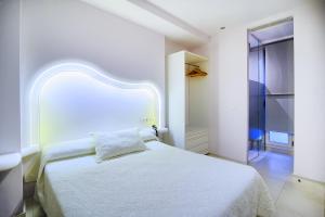 a bedroom with a white bed with a white headboard at Hotel Boutique Sabbia Valencia in Valencia