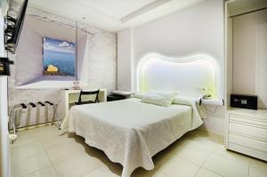 a white bedroom with a bed and a window at Hotel Boutique Sabbia Valencia in Valencia
