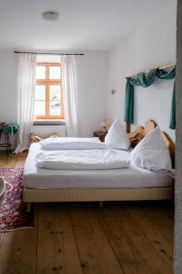 ein Schlafzimmer mit einem großen Bett mit weißer Bettwäsche in der Unterkunft Posthotel Sachrang in Sachrang