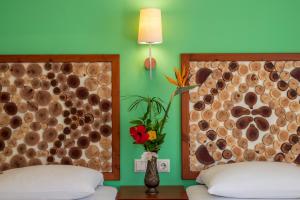 una stanza con due letti e un vaso con un fiore di Aris Boutique Hotel a Palaiochóra
