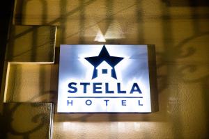 een bord voor een stella hotel aan een muur bij Stella Hotel Tashkent in Tasjkent