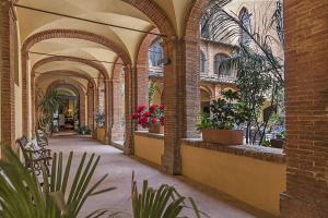 um corredor vazio com plantas num edifício em Il Chiostro Del Carmine em Siena