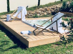 a deck with a chair and a hot tub at COTTAGES ANTOINETTE in Chigny-les-Roses