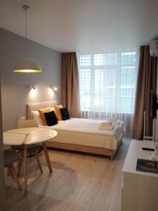 a bedroom with a bed and a table and a window at Studio Galaxy 2 floor in Kyiv