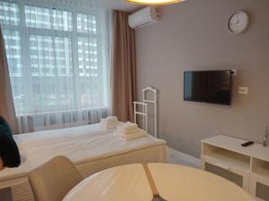 a hotel room with a bed and a tv on the wall at Studio Galaxy 2 floor in Kyiv