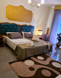 a bedroom with a bed with a blue headboard and a rug at Hotel La Conca in Villa San Giovanni