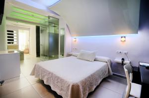 a bedroom with a bed and a glass shower at Hotel Boutique Sabbia Valencia in Valencia