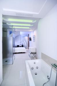 a white bathroom with a tub and a bed at Hotel Boutique Sabbia Valencia in Valencia