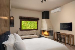 a bedroom with a bed and a fireplace and a window at 19.40 Luxury Guesthouse in Kalpákion