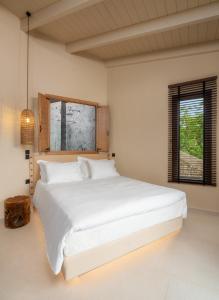 een slaapkamer met een groot wit bed en een raam bij 19.40 Luxury Guesthouse in Kalpákion