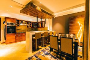 a kitchen with a bar with chairs in it at Blackwood Boutique Hotel and Apartments in Dar es Salaam