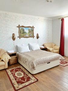 um quarto com uma cama e 2 cadeiras em Hotel Aristokrat em Ufa