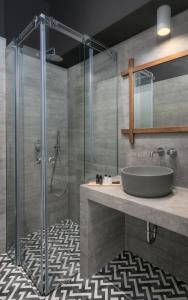 a bathroom with a sink and a glass shower at 19.40 Luxury Guesthouse in Kalpákion
