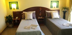 two beds in a hotel room with two at Hotel La Conca in Villa San Giovanni