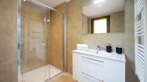 ein Bad mit einer Dusche, einem Waschbecken und einem Spiegel in der Unterkunft Les Freinets - Apt C302 - BO Immobilier in Châtel