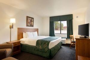 a hotel room with a bed and a television at Travelodge by Wyndham Dexter in Dexter