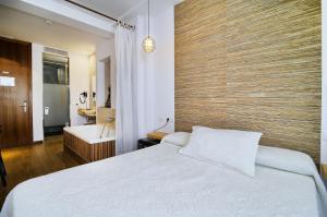 a bedroom with a large bed and a bathroom at Hotel Boutique Sabbia Valencia in Valencia