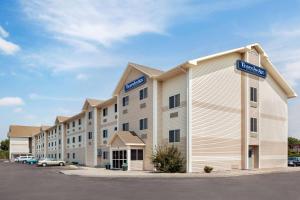 a large hotel building with blue signs on it at Travelodge by Wyndham North Platte in North Platte