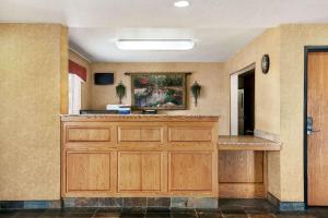 a large kitchen with wooden cabinets and a painting on the wall at Travelodge by Wyndham North Platte in North Platte