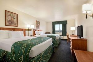 a hotel room with two beds and a flat screen tv at Travelodge by Wyndham North Platte in North Platte