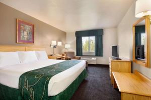 a hotel room with a bed and a television at Travelodge by Wyndham Yermo in Yermo