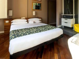 Cama grande en habitación con suelo de madera en Hotel Ferrara, en Ferrara