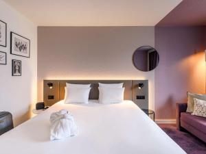 a bedroom with a large white bed and a couch at Novotel Zurich City West in Zurich