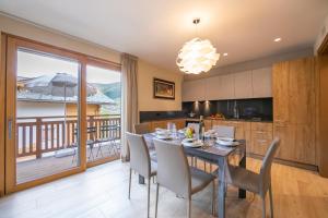 cocina y comedor con mesa y sillas en Casa Luminosa Ski in -Ski out 100m - Happy Rentals en Livigno