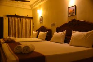 duas camas num quarto de hotel com toalhas em Hotel Raja Palace em Kanyakumari