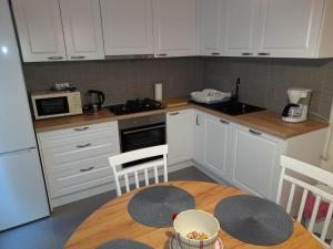 een keuken met een tafel en een keuken met witte kasten bij Apartment Pavlito in Dubrovnik