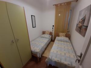een kleine kamer met 2 bedden en een deur bij Apartment Pavlito in Dubrovnik