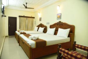 a bedroom with two beds with towels on them at Hotel Raja Palace in Kanyakumari