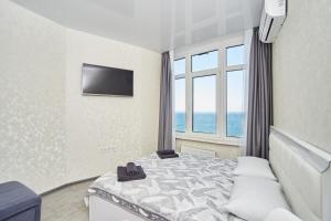 um quarto de hotel com uma cama e uma janela em Панорамный вид на море 44 Жемчужина Аркадия em Odessa