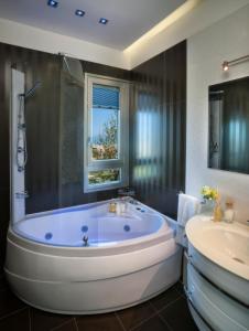 a bathroom with a large tub and a sink at Hotel Vistamare in Rimini