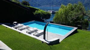 una piscina con tumbonas en el césped en OSSUCCIO VILLA ON THE LAKE, en Como