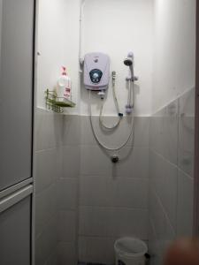 a shower in a bathroom with a soap dispenser at JOKA-JOKA GUESTHOUSE in Melaka