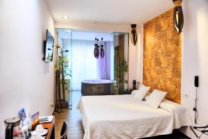 a bedroom with a bed and a tub in a room at Hotel Sabbia by Gabbeach in Valencia