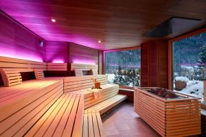una sauna con iluminación púrpura en un lodge de esquí en Adler Inn Tyrol Mountain Resort SUPERIOR, en Tux