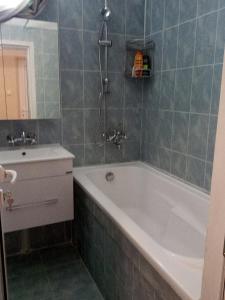 a bathroom with a tub and a sink at Просторен и добре обзаведен апартамент Oborishte 39 str in Plovdiv