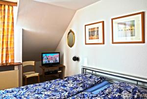 ein Hotelzimmer mit einem Bett und einem TV in der Unterkunft Ferienwohnung bei Stadthagen mit Wlan und Waschmaschine in Niedernwöhren