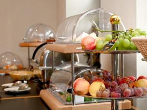 a bunch of different types of fruits on three tiers at Hotel Brandenburger Dom in Brandenburg an der Havel