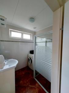 a bathroom with a sink and a washing machine at Siësta in Westkapelle
