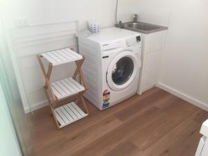 a laundry room with a washing machine and a sink at Old Pier Apartments in Bridport